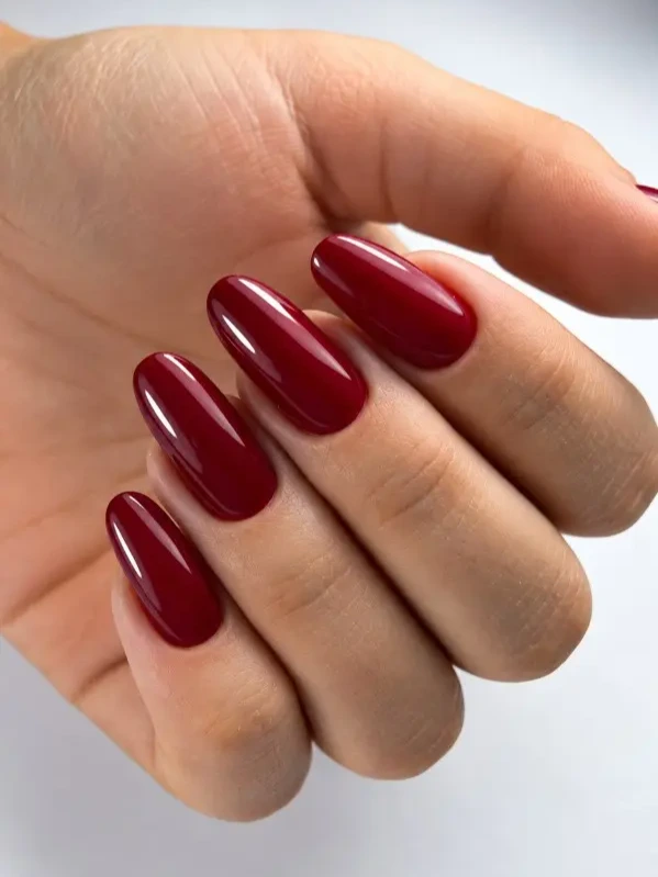 Głębokie bordowe paznokcie migdałowe w eleganckim połysku