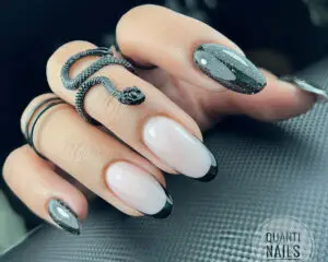 Manicure żelowy z niezwykłym czarnym brokatowym frenchem. Paznokcie pokryte żelem w kolorze naturalnej płytki. Na końcu serdecznego i środkowego paznokcia czarny błyszczący pasek, tworzący efekt mieniącego się francuskiego akcentu. Brokat dodaje manicure'owi wyjątkowego charakteru i eleganckiego wyglądu.